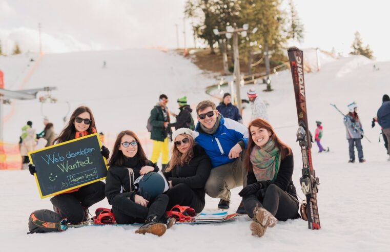 group of people sitting on snow taking photo